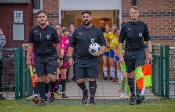 Three grassroots referees walk out onto pitch 